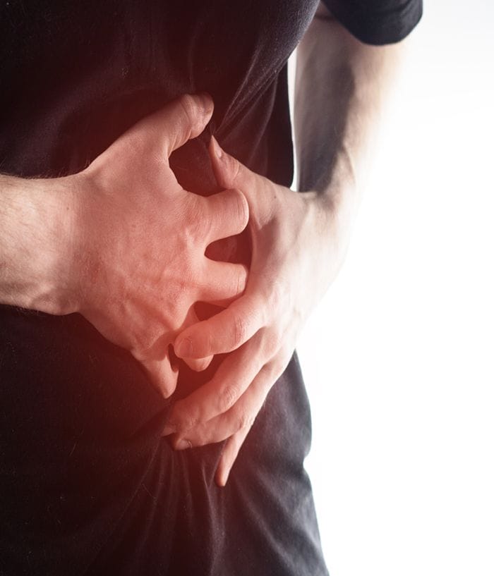 A close-up shot of a patient suffering from severe abdomen pain.