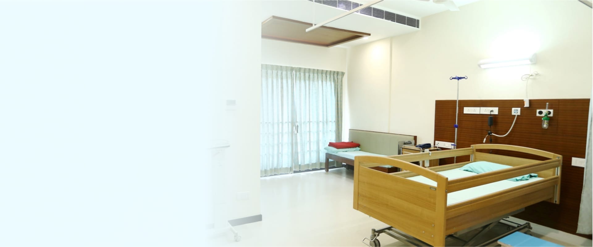 A clean and well-equipped room with a bed and medical equipment at Sri Balaji Hospital, Chennai.
