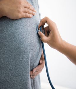 A close-up shot of a medical expert diagnosing a pregnant woman illustrates obstetrics and Gynaecology.