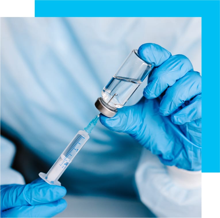 Image of a doctor extracting the needed dosage of medicine into a syringe.