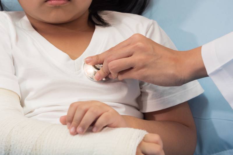 A medical professional evaluating a child's fracture.