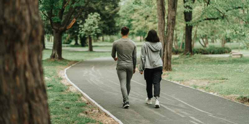 A young couple walking outdoors to support bone health.