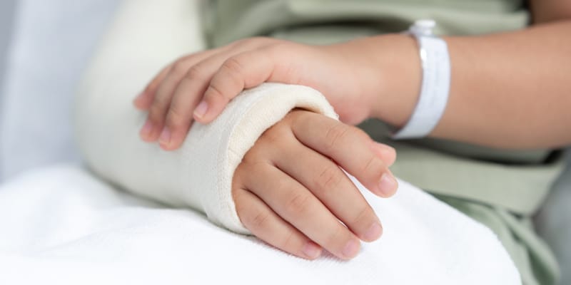 Young girl with her arm in a cast, illustrating common childhood fractures parents should be aware of.